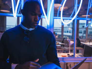 Young professional working on a laptop in a modern office setting.